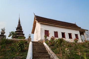 Old and aged chedi or stupa next to the Buddhist Wat Chompet (Chomphet) Temple in Luang Prabang, Laos, on a sunny day.