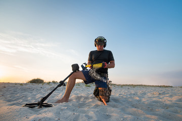 Fototapeta na wymiar Man with a metal detector on a sea sandy beach