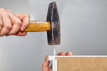 Installation of drawer using plastic dowel pin and hammer.
