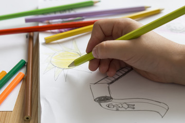child draws a picture with colorful pens on the white art paper in the lesson.education concept for nursery or school concept.back to school.