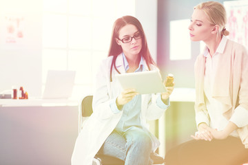 Doctor and patient discussing something while sitting at the table . Medicine and health care...