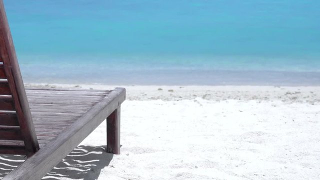 One sunbed on tropical calm shore with turquoise sea water and white sand