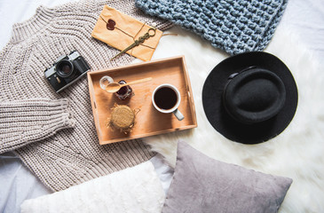 Top view mug of beverage and jars of mead situating in tray near camera and black hat on carpet. Breakfast concept