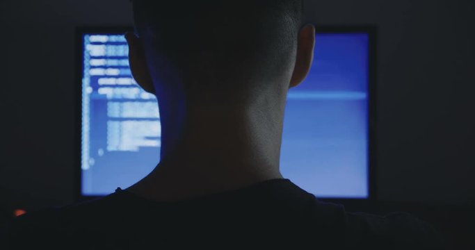 IT Programmer man typing in program code. Developer at work overtime. Hacker hacking late at night.