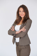 Modern business woman in suit with her arms crossed standing on gray background. Copy space. Dress Code. Business concept.