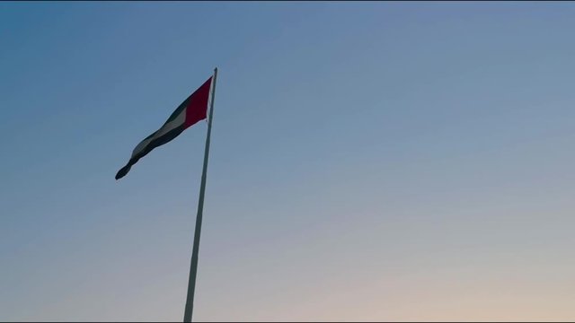 The United Arab Emirates flags waving in Abu Dhabi city