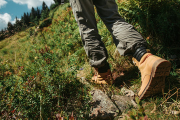 I am coming. Close up of female legs in stylish boots on the road with grass. Young lady heading to...