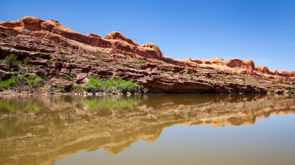 Water view from the Colorado River along the bluffs and rock sculpture outside Moab, Utah