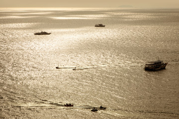 Silhouetted boats on shiny sea 