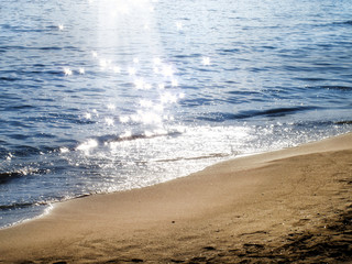 Landscape of sandy beach and sun shining on sea
