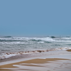 Landscape image of sandy beach and sea with waves  