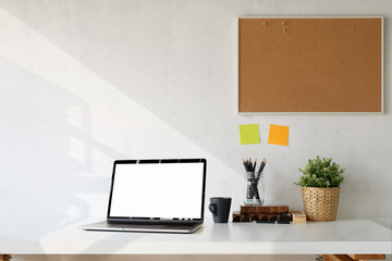 Workspace mockup blank screen laptop, cork board and supplies.