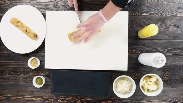 Hands cutting sushi roll. Japanese food preparation top view.