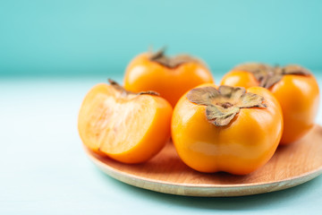 Ripe persimmon fruit on wooden plate