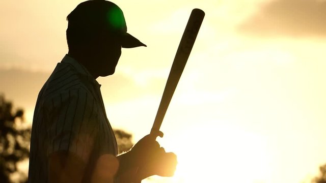 Men's baseball practice hitting a baseball with the light of sunset footage slow motion