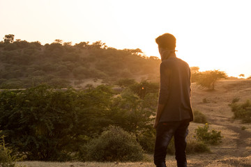 man in desert looking at hills