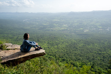 A woman backpacker sits on rock