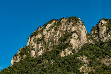 Fototapeta na wymiar unique peaks covered with green forest under the blue sky at mount Sanqing geo Park