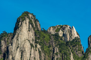 unique peaks covered with green forest under the blue sky at mount Sanqing geo Park