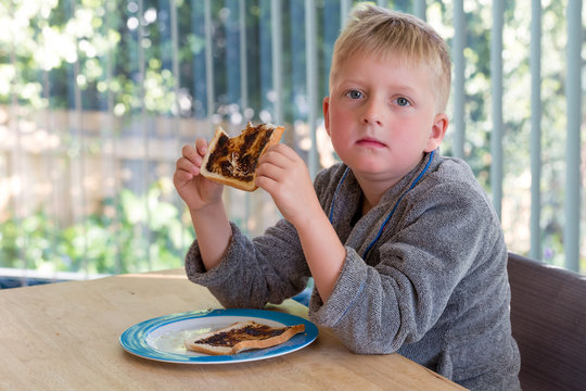 Young boy eating vegemite toast for breakfast 