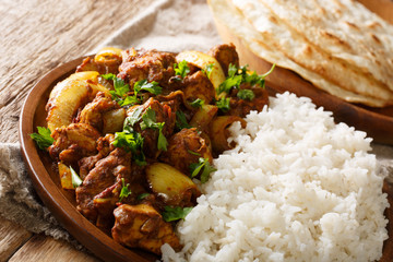 Spicy Indian chicken Do Pyaaza with onions served with garnish of rice close-up on a plate. horizontal