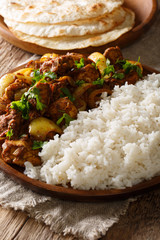 Chicken do pyaza (dopiaza) is cooked in onion and tomato gravy along with spices served with rice and flatbread. Vertical