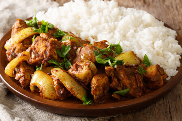 Chicken do pyaza (dopiaza) recipe with onion with garnish of rice close-up. horizontal