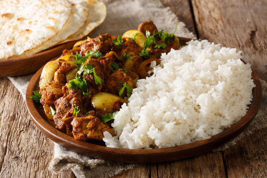Spicy Chicken do pyaza curry which has double the amount of onions with garnish of rice close-up on a plate. Horizontal