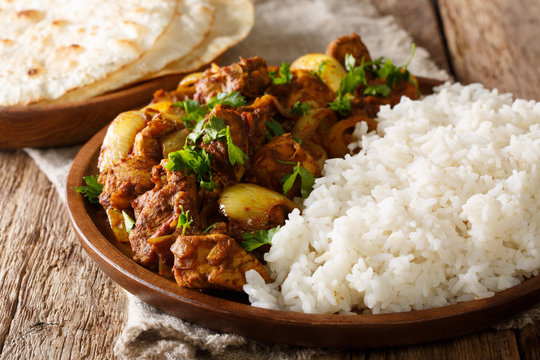 delicious Indian Punjabi chicken dopiaza with onions served with a side dish of rice close-up on a plate. horizontal