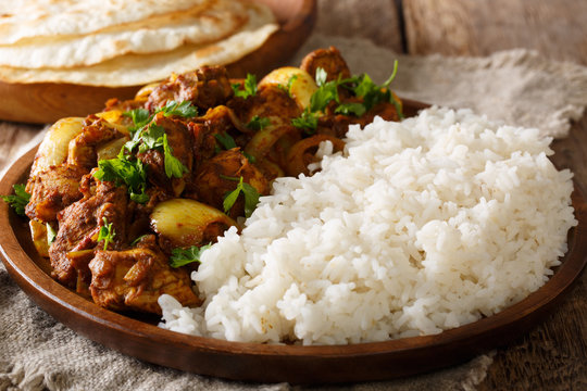 Chicken Do Pyaaza cooked in a variety of spices, yogurt and kasoori methi served with rice and flatbread. horizontal