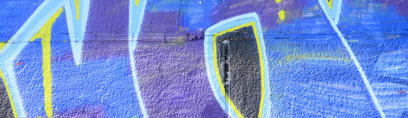 Fragment of graffiti drawings. The old wall decorated with paint stains in the style of street art culture. Colored background texture in cold tones