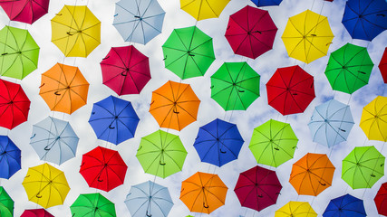 Fototapeta na wymiar multicolored hanging umbrellas against the blue sky