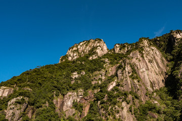 Fototapeta na wymiar unique peaks of Mt. SanQiang covered in green under cloudy blue sky