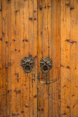 brown Chinese wooden doors with rusted metal door nobs