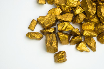 A pile of gold nuggets or gold ore isolated on white background, precious stone or lump of golden stone, financial and business concept.