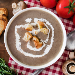 Mushroom cream soup with herbs and spices. Homemade, country styled chanterelle Cream-soup on wooden table.