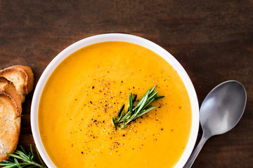 Pumpkin and carrot  Cream soup on  wood rustic  background. Autumn cream-soup in country style. Top...