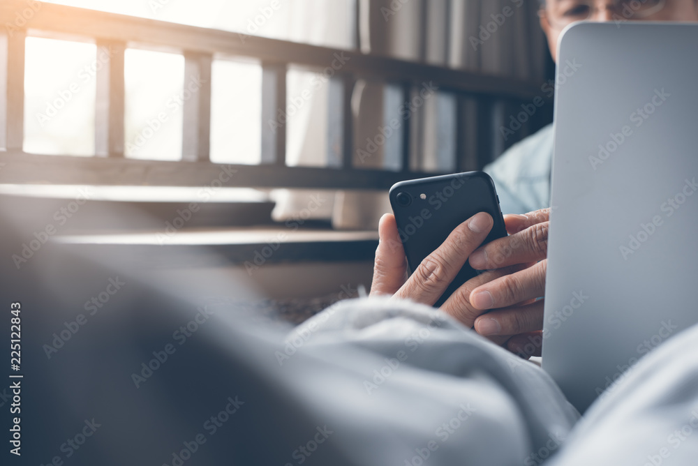 Poster man using smartphone and laptop computer