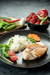 Grilled chicken fillet on plate with boiled rice