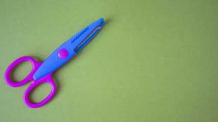 baby scissors on a green background. View from above