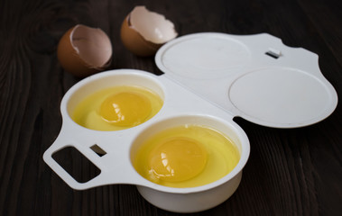 raw eggs in a container on wooden background. Top view.