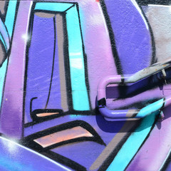 Fragment of graffiti drawings. The old wall decorated with paint stains in the style of street art culture. Colored background texture in purple tones
