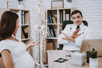 Doctor in White. Pregnant Woman. Talk Seriously.