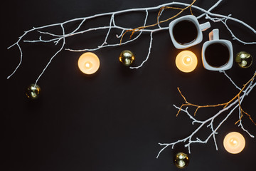 Winter composition. Two cups of coffee, branches, candles and Christmas toys on a dark background....