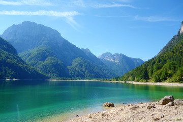 Lago del Predil (Predil Lake), small mountain lake with turquoise water in Julian Alps, Tarvisio with mountains in background, Italy