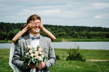 The first meeting is newlyweds on a green field outdoors. Bride goes back to the groom, surprise in...