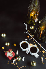 Winter composition. Two cups of coffee, branches, candles and Christmas toys on a dark background. Flat lay
