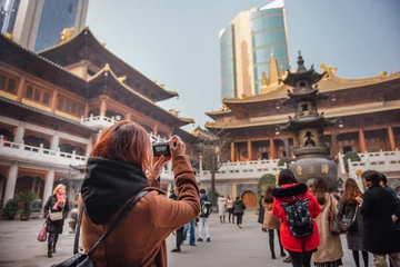 Papier Peint photo Shanghai Jeune femme touristique prenant une photo au temple jing& 39 an dans le centre-ville de shanghai, en chine. Une jeune femme asiatique en veste à l& 39 aide d& 39 un appareil photo prend une photo du temple de shanghai.