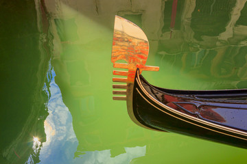 Venice: reflections, lights and colors. Particular of the iron prow-head of the gondola. The ornaments on the front  of the Gondola represent symbols of Venice. © vololibero
