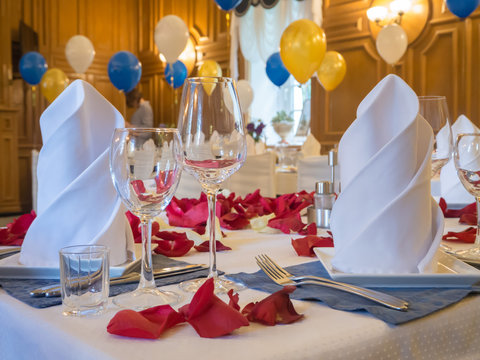 Table served with glasses, rose petals and balloons in the restaurant.
